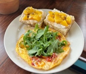Open-faced pasture-raised egg omelette with farm greens and seasonal toast at All-Vegetarian favorite Bouldin Creek Cafe in Austin, TX
